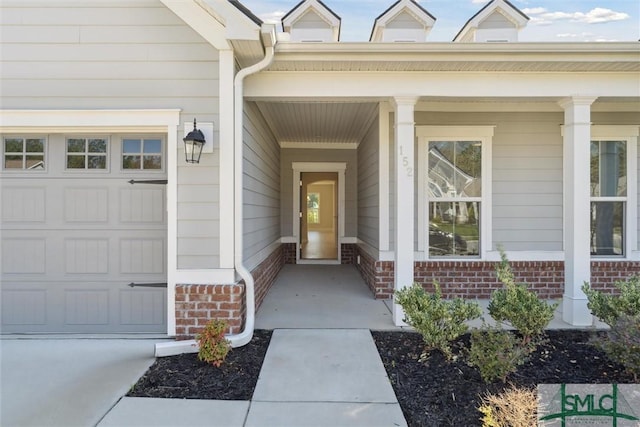 property entrance with a porch and brick siding