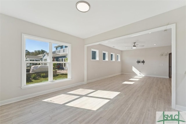 unfurnished living room featuring light wood-type flooring, baseboards, plenty of natural light, and ceiling fan