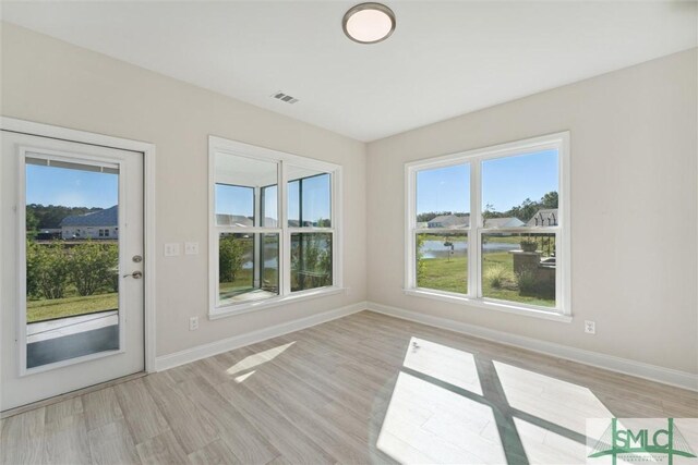 unfurnished room featuring baseboards and light wood finished floors