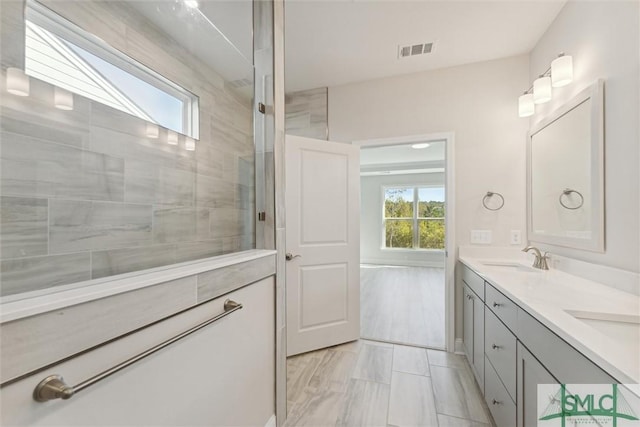 bathroom featuring a walk in shower and double vanity
