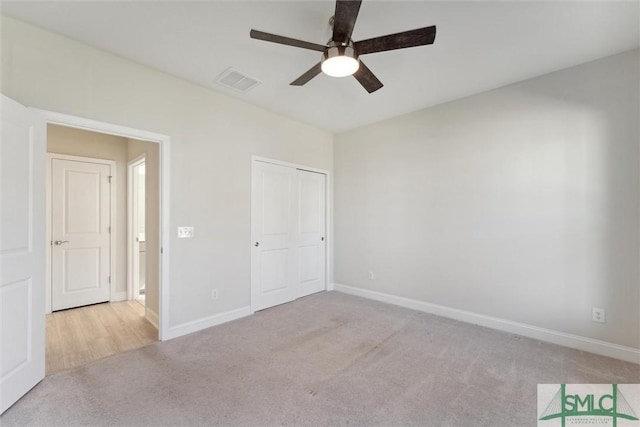 unfurnished bedroom with carpet flooring, baseboards, a closet, and a ceiling fan