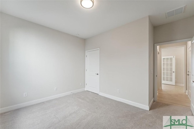 unfurnished bedroom with light colored carpet and baseboards