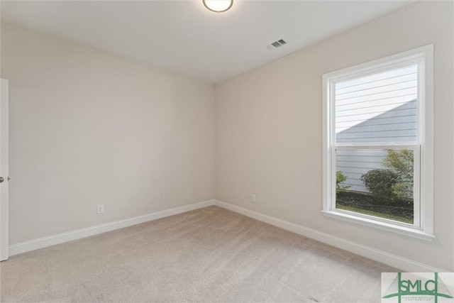 unfurnished room featuring light carpet and baseboards