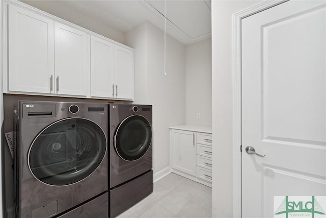 laundry room featuring cabinet space, washing machine and clothes dryer, attic access, light tile patterned floors, and baseboards