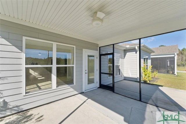 unfurnished sunroom featuring ceiling fan