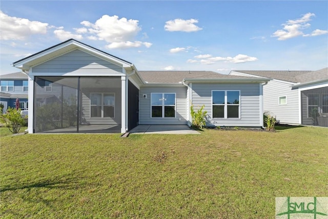 back of property featuring a patio area, a lawn, and a sunroom