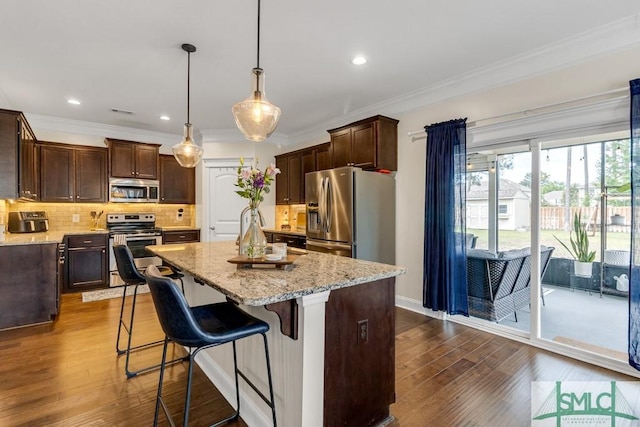kitchen featuring stainless steel appliances, dark wood-style flooring, a center island, light stone countertops, and recessed lighting