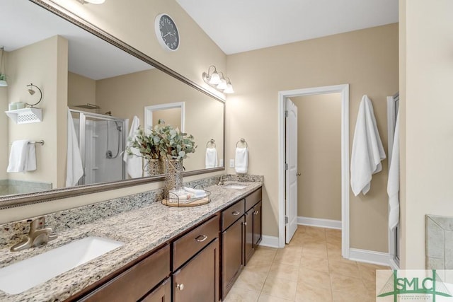 bathroom featuring a shower stall, tile patterned floors, double vanity, and baseboards