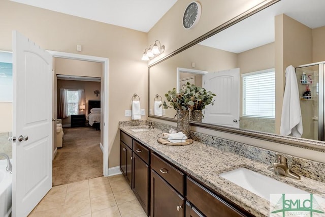 ensuite bathroom with double vanity, a shower with door, tile patterned flooring, and baseboards