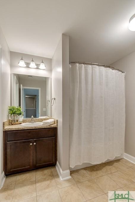 full bath with baseboards, vanity, and tile patterned flooring