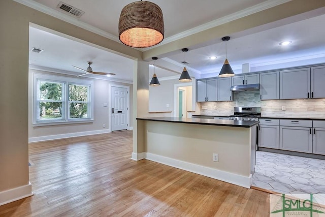 417 E 61st St, Savannah, GA 31405 - kitchen with under cabinet range hood, stainless steel range oven, backsplash, light wood finished floors, and ornamental molding