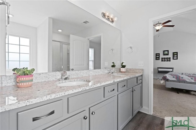 ensuite bathroom with ceiling fan, double vanity, wood finished floors, recessed lighting, and baseboards