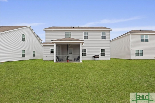 rear view of house featuring a yard and a sunroom
