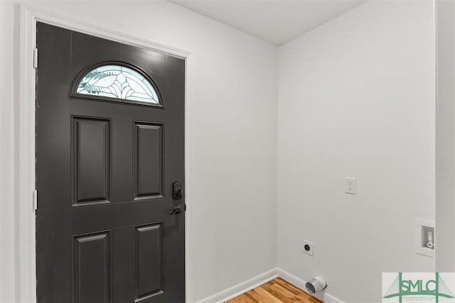 foyer entrance with light wood finished floors and baseboards