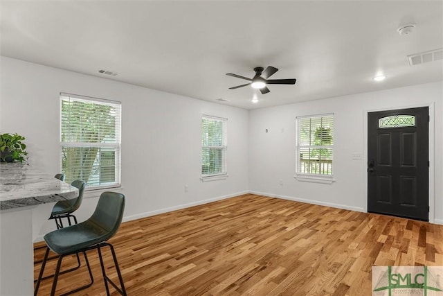 interior space with light wood-style floors, baseboards, and a ceiling fan