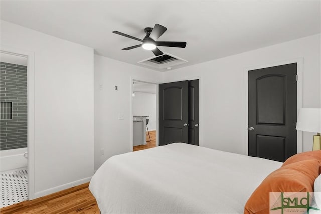 bedroom featuring baseboards, light wood finished floors, a ceiling fan, and connected bathroom
