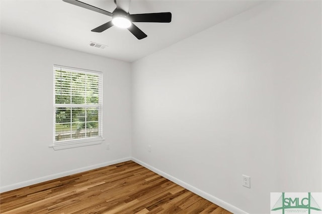 spare room featuring baseboards, light wood finished floors, and ceiling fan