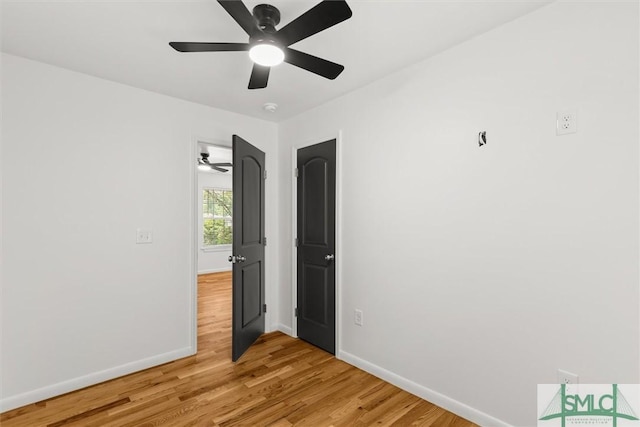 unfurnished bedroom featuring baseboards, light wood-style floors, and a ceiling fan