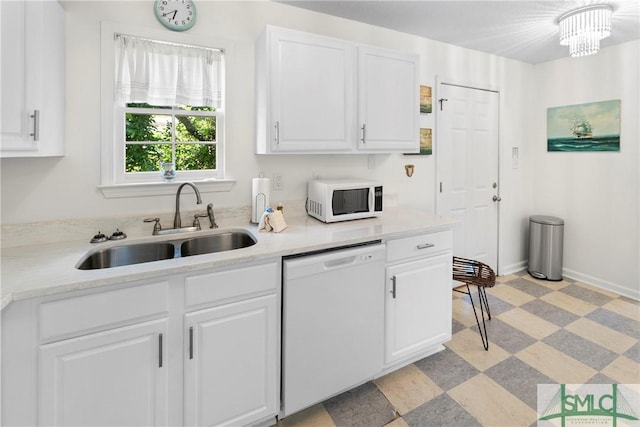 524 Nicoll St, Savannah, GA 31401 - kitchen with white appliances, a sink, light countertops, light floors, and white cabinets
