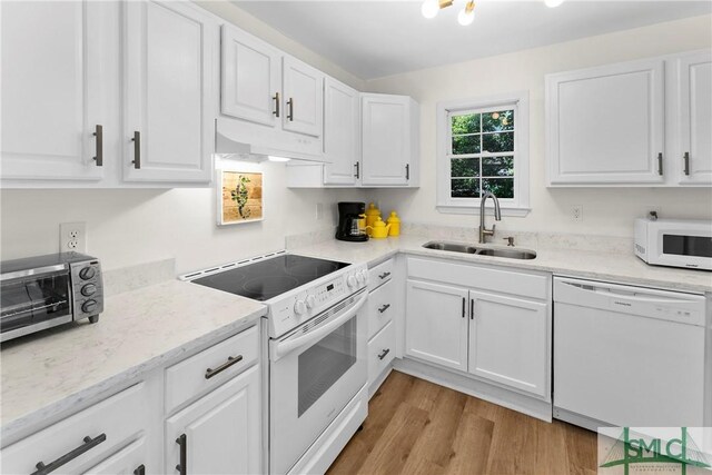 524 Nicoll St, Savannah, GA 31401 - kitchen with white appliances, under cabinet range hood, a sink, and white cabinetry