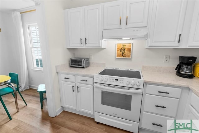 524 Nicoll St, Savannah, GA 31401 - kitchen featuring electric stove, under cabinet range hood, light wood-type flooring, white cabinets, and baseboards