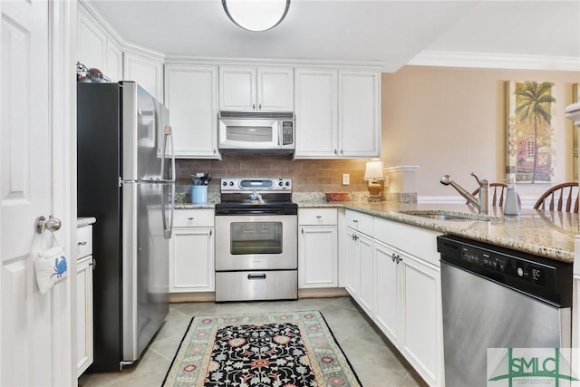 kitchen with appliances with stainless steel finishes, a sink, white cabinets, and crown molding