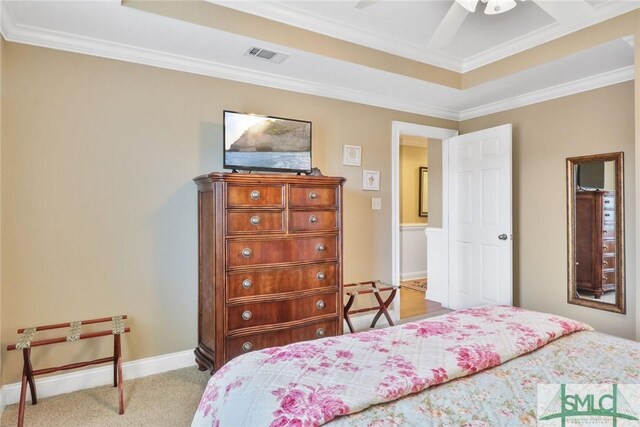 carpeted bedroom featuring a raised ceiling, crown molding, baseboards, and ceiling fan