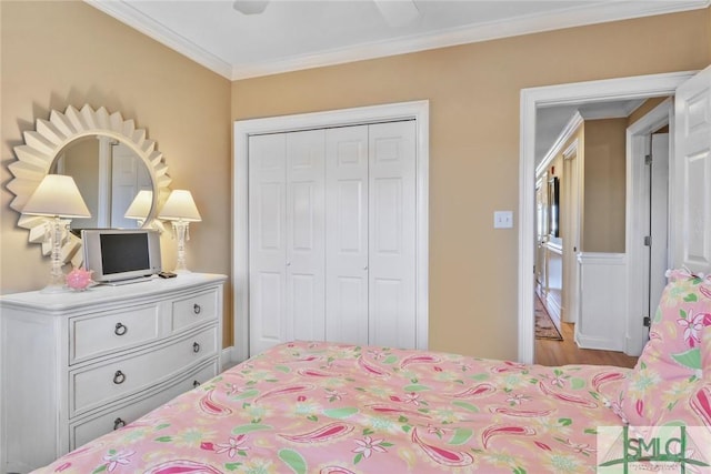 bedroom featuring a closet, crown molding, wood finished floors, and ceiling fan