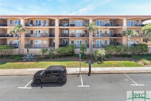 view of apartment building / complex featuring uncovered parking
