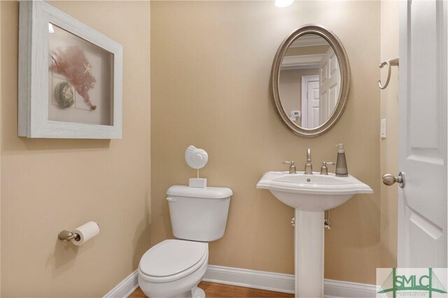 half bathroom with toilet and baseboards