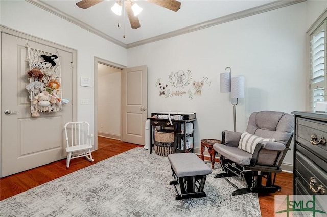 sitting room with wood finished floors, ceiling fan, ornamental molding, and baseboards