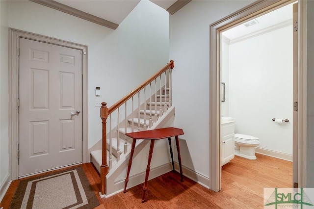 foyer featuring light wood-style floors, stairway, baseboards, and ornamental molding