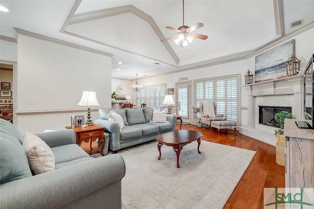 living room with wood finished floors, ceiling fan, recessed lighting, a tile fireplace, and ornamental molding