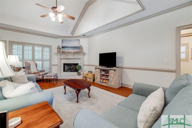 living area featuring lofted ceiling, wood finished floors, a ceiling fan, and healthy amount of natural light