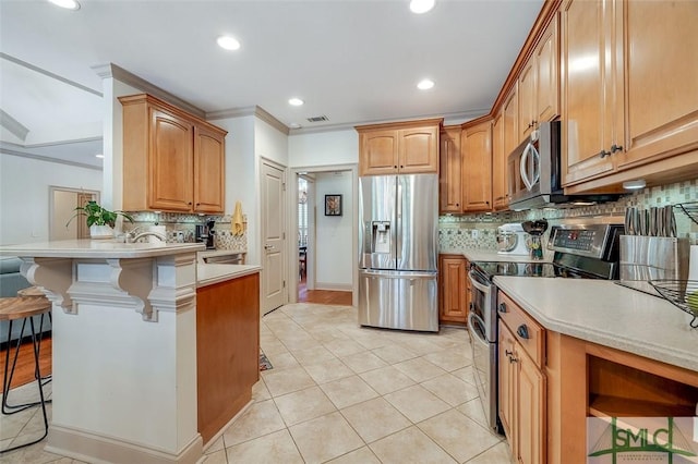 kitchen with stainless steel appliances, a breakfast bar area, backsplash, a peninsula, and recessed lighting