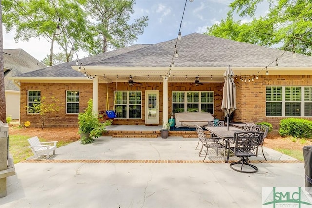 back of house featuring a ceiling fan, roof with shingles, a patio area, and brick siding
