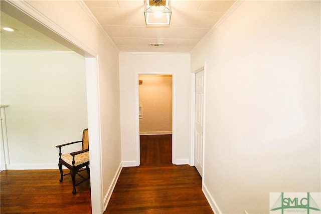 corridor featuring wood finished floors, crown molding, and baseboards