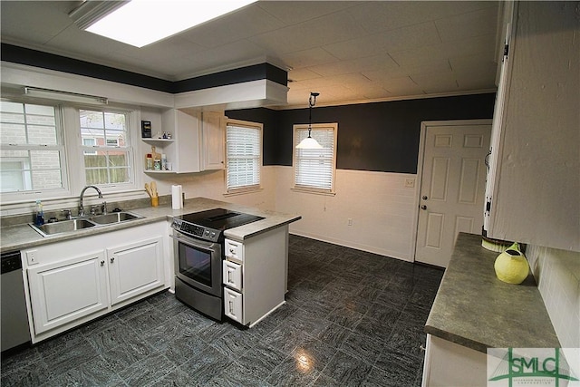 kitchen featuring stainless steel appliances, a sink, a peninsula, crown molding, and white cabinets
