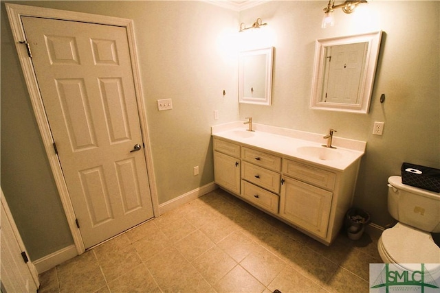 full bath with toilet, double vanity, ornamental molding, baseboards, and tile patterned flooring