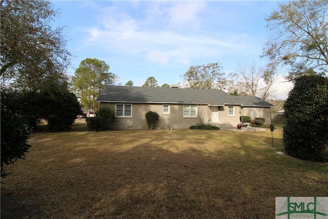 rear view of property featuring a lawn