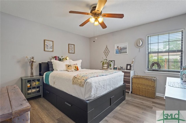 bedroom with wood finished floors, a ceiling fan, and baseboards