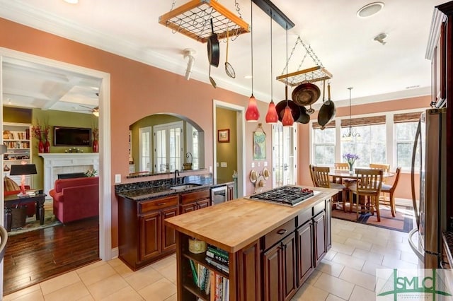 18 Enclave Cir, Savannah, GA 31419 - kitchen with wood counters, stainless steel appliances, a tile fireplace, a sink, and arched walkways