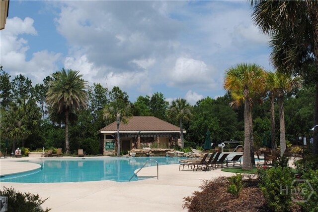 18 Enclave Cir, Savannah, GA 31419 - community pool featuring a patio and view of wooded area