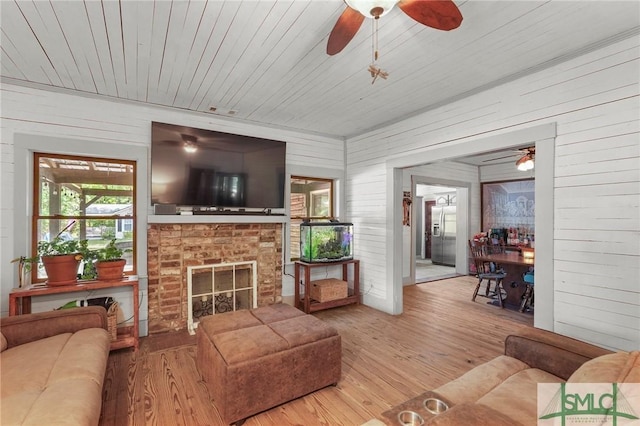 309 E 5th St, Rincon, GA 31326 - living area featuring ceiling fan, wood finished floors, wooden walls, wood ceiling, and a fireplace
