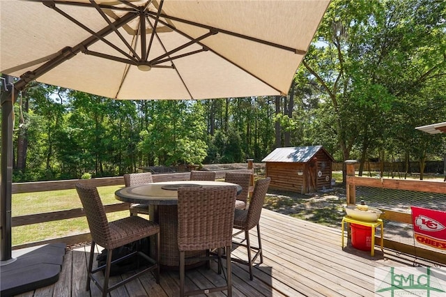 309 E 5th St, Rincon, GA 31326 - wooden terrace with outdoor dining area, a storage unit, and an outdoor structure