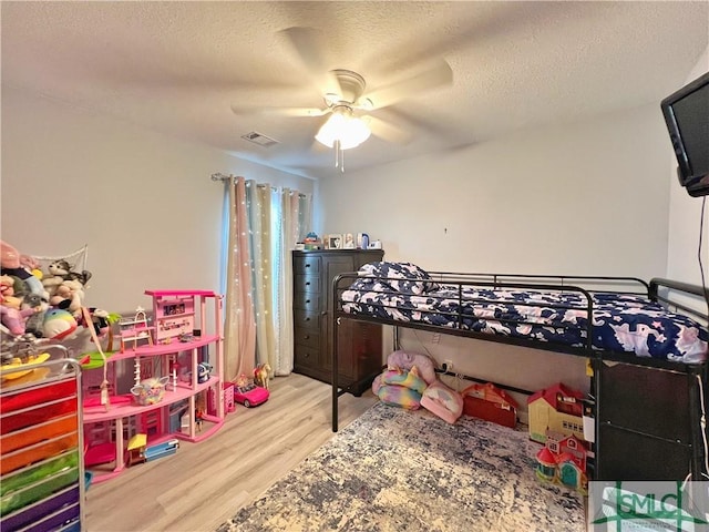 111 Auburn Cir, Glennville, GA 30427 - bedroom featuring wood finished floors, a textured ceiling, and ceiling fan