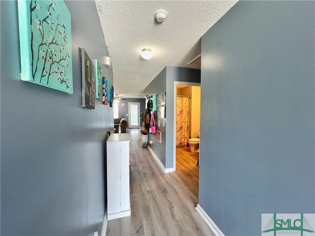 111 Auburn Cir, Glennville, GA 30427 - hall featuring light wood-style flooring, a textured ceiling, and baseboards