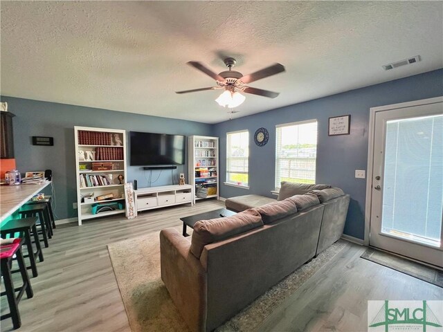 111 Auburn Cir, Glennville, GA 30427 - living room with a textured ceiling, light wood-type flooring, a ceiling fan, and baseboards