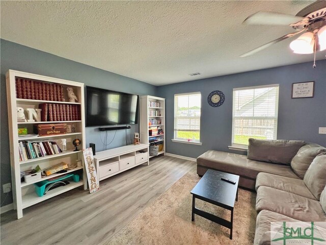 111 Auburn Cir, Glennville, GA 30427 - living room with wood finished floors, a textured ceiling, a ceiling fan, and baseboards
