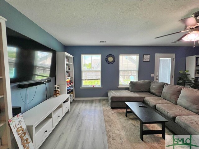 111 Auburn Cir, Glennville, GA 30427 - living room with a textured ceiling, a ceiling fan, light wood finished floors, and baseboards